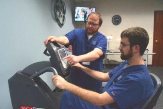 YOA physical therapists Ron Santiago (left) and Alex Janosik with a new recumbent bicycle.